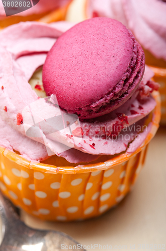 Image of pink berry cream cupcake with macaroon on top