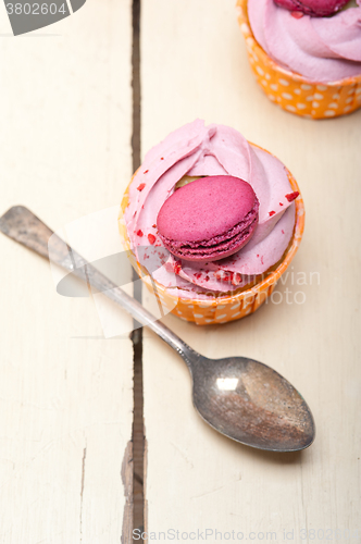 Image of pink berry cream cupcake with macaroon on top