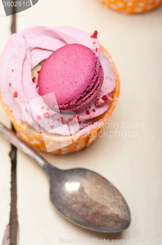 Image of pink berry cream cupcake with macaroon on top