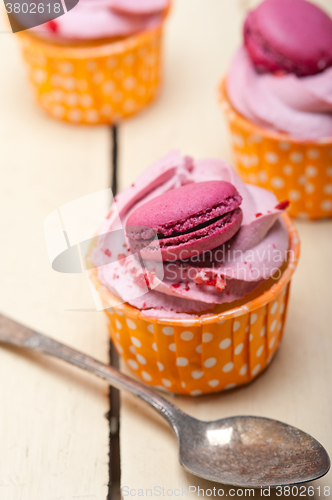 Image of pink berry cream cupcake with macaroon on top