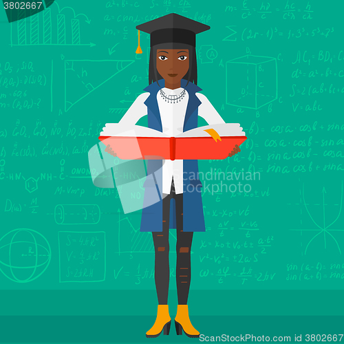 Image of Woman in graduation cap holding book.
