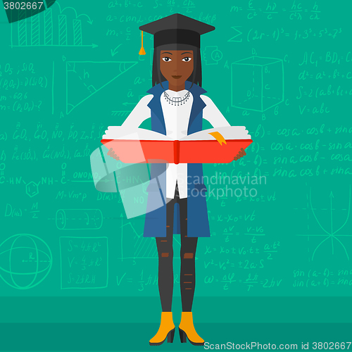 Image of Woman in graduation cap holding book.