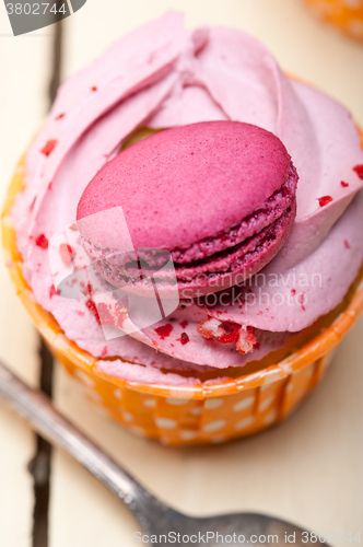 Image of pink berry cream cupcake with macaroon on top