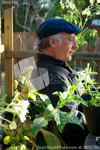 Image of profile of man sitting in garden