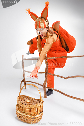 Image of Young woman in the image of red squirrel with walnuts 