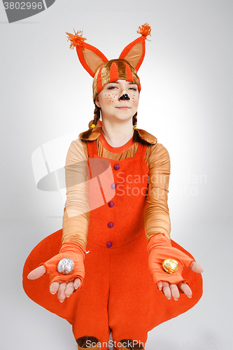 Image of Young woman in the image of red squirrel with cookies