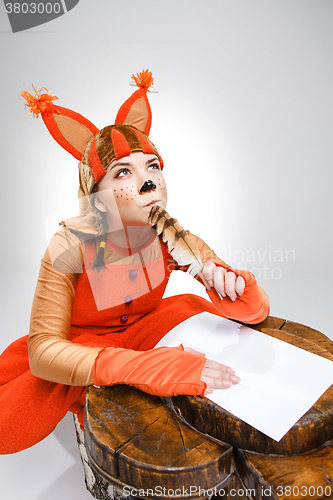 Image of Young woman in image of squirrel writing with quill pen