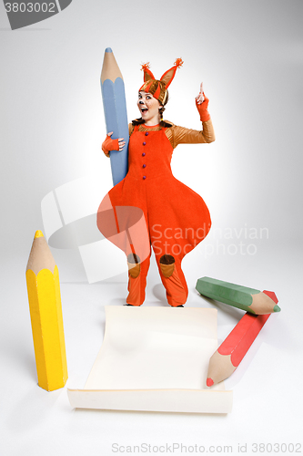 Image of Young woman in image of squirrel with large pencils