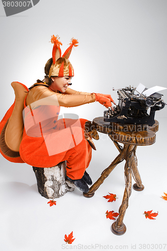 Image of Young woman in image of squirrel with a retro typewriter