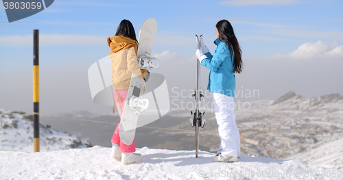 Image of Two women snowboarders enjoying the winter view