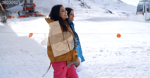 Image of Two young women walking through snow at a resort