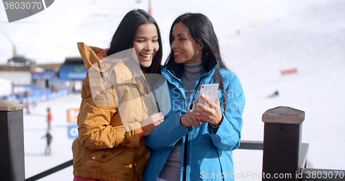 Image of Two smiling young women checking a phone