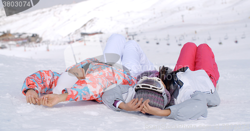 Image of Two skiers laying on the ground