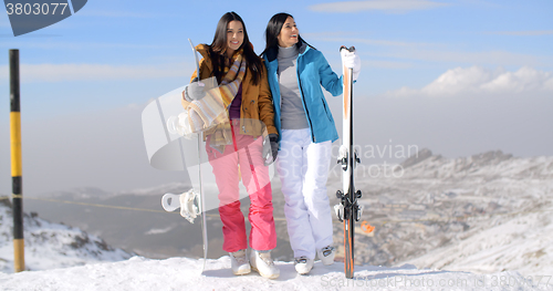 Image of Two female snowboarders standing on a mountain