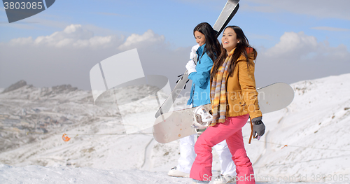 Image of Two friends hiking up ski slope