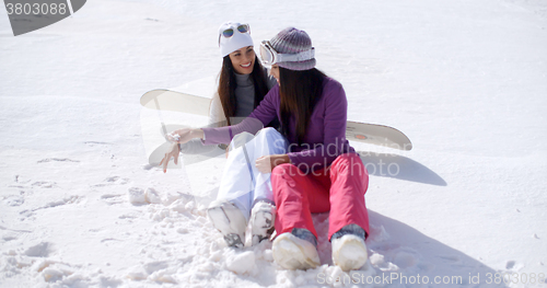 Image of Two young women sitting chatting in the snow