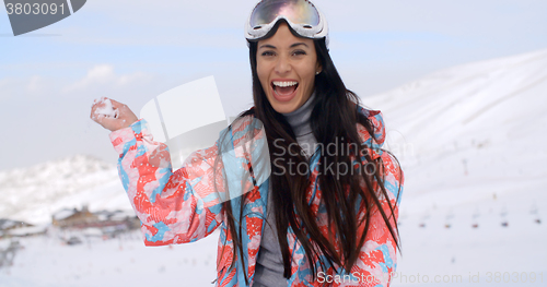 Image of Laughing young woman throwing a snowball