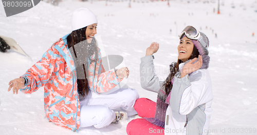 Image of Two young female friends chatting in the snow