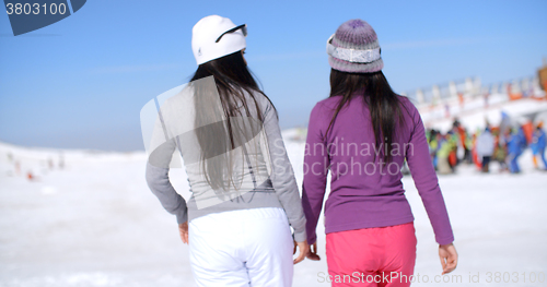 Image of Two young woman walking in a winter ski resort