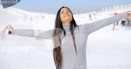 Image of Young woman rejoicing in the winter weather