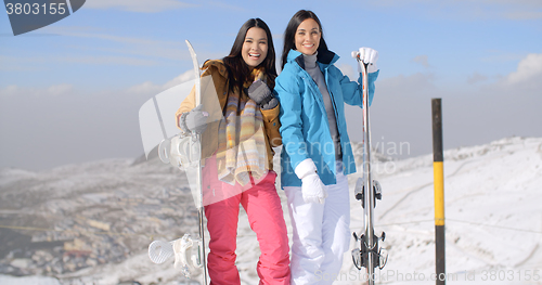 Image of Two young woman with their snowboards