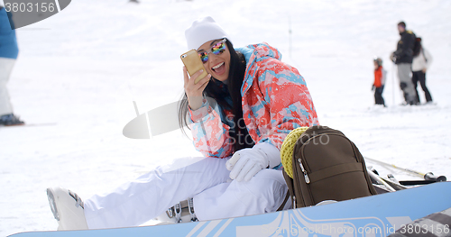 Image of Happy young woman posing for a selfie in the snow