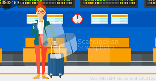 Image of Woman standing with suitcase and holding ticket.