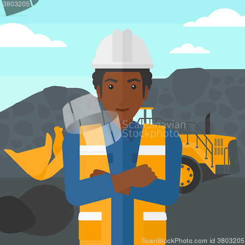 Image of Miner with mining equipment on background.