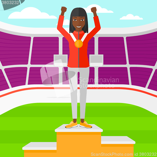 Image of Athlete with medal and hands raised.