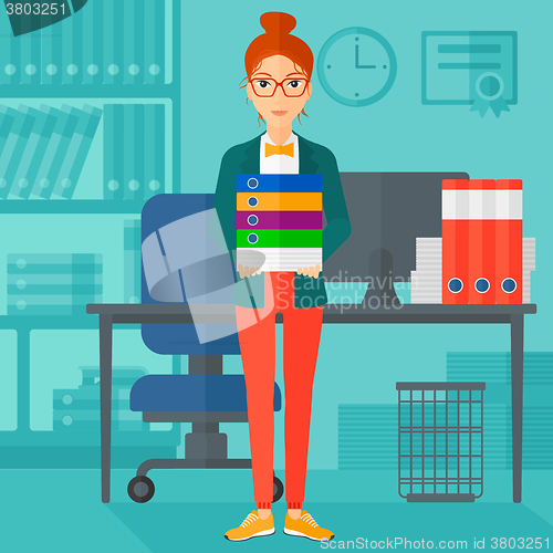Image of Woman holding pile of folders.