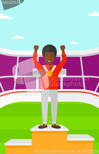 Image of Athlete with medal and hands raised.