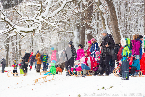 Image of Winter fun, snow, family sledding at winter time.