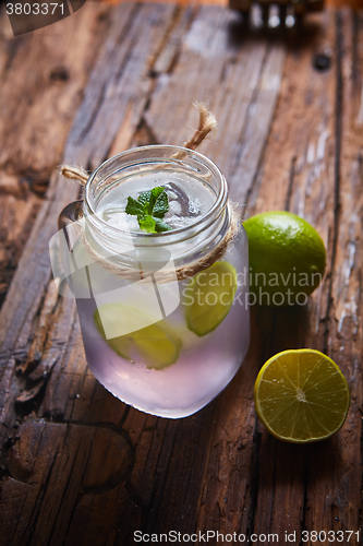 Image of fresh mojito on a rustic table.