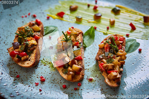 Image of Vegan food: bruschetta with bell pepper, tomatoes, arugula, thyme and basil