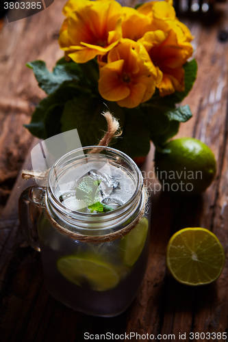 Image of fresh mojito on a rustic table.