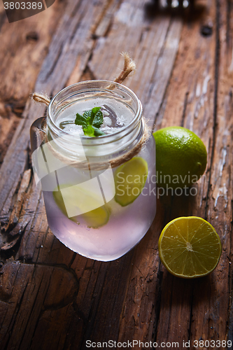 Image of fresh mojito on a rustic table.