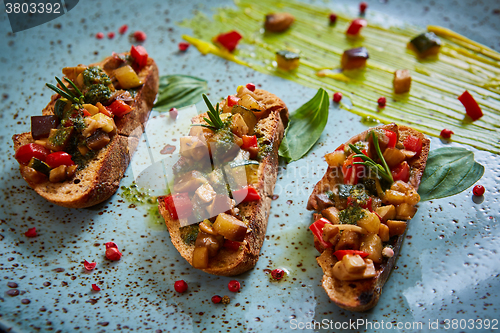 Image of Vegan food: bruschetta with bell pepper, tomatoes, arugula, thyme and basil