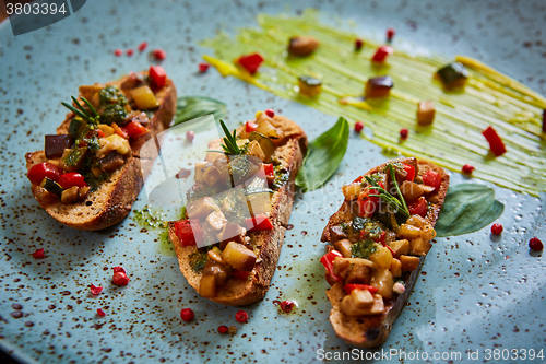 Image of Vegan food: bruschetta with bell pepper, tomatoes, arugula, thyme and basil