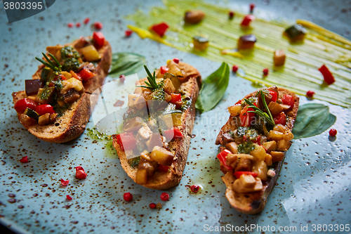 Image of Vegan food: bruschetta with bell pepper, tomatoes, arugula, thyme and basil