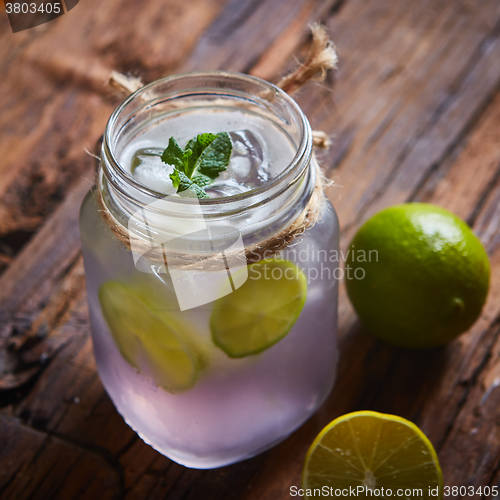 Image of fresh mojito on a rustic table.