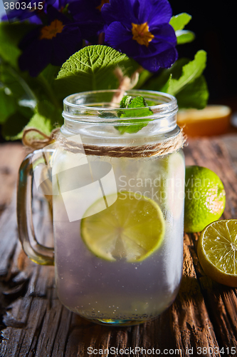 Image of fresh mojito on a rustic table.