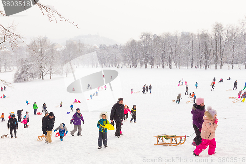 Image of Winter fun, snow, family sledding at winter time.