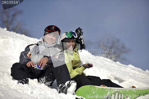 Image of snowboarders couple relaxing