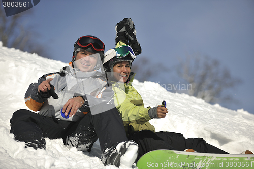 Image of snowboarders couple relaxing