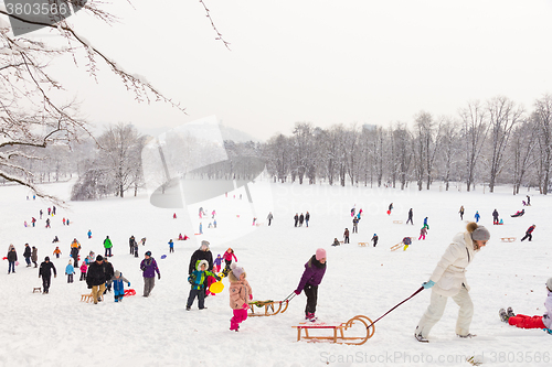 Image of Winter fun, snow, family sledding at winter time.