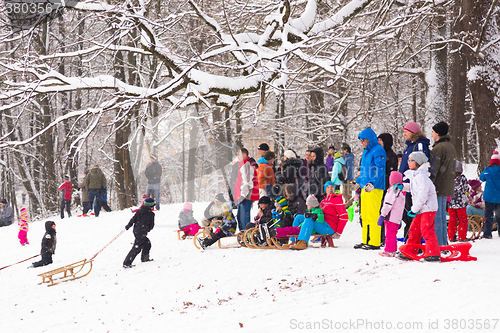 Image of Winter fun, snow, family sledding at winter time.