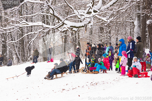 Image of Winter fun, snow, family sledding at winter time.