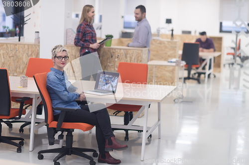 Image of portrait of young business woman at office with team in backgrou