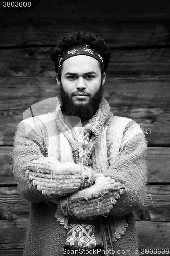 Image of portrait of young hipster in front of wooden house