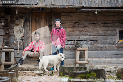 Image of frineds together in front of old wooden house